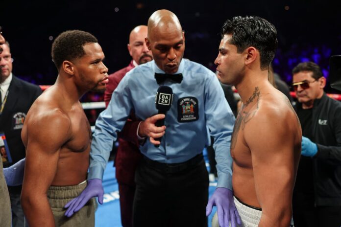 Referee gives instructions to boxers Devin Haney and Ryan Garcia during their bout