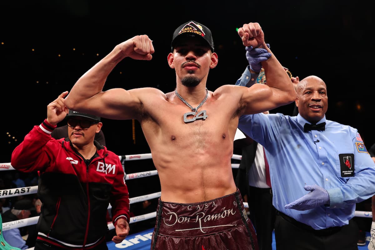 Referee Allen Huggins raises boxer Diego Pacheco's hand in victory