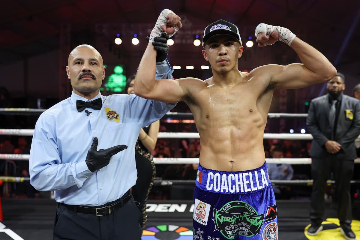 Referee Ivan Guillermo raises boxer Grant Flores' hand in victory