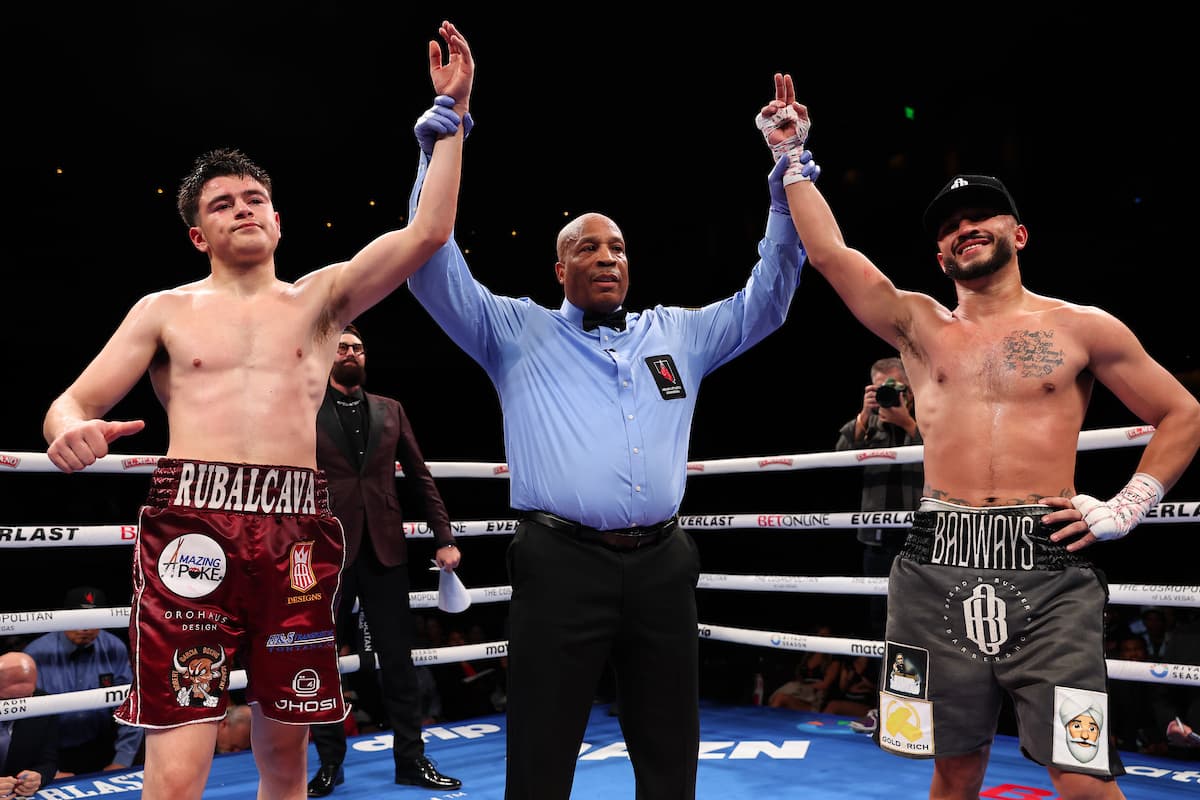 Referee Allen Huggins raises the hands of boxers Leonardo Rubalcava and Israel Mercado in a draw