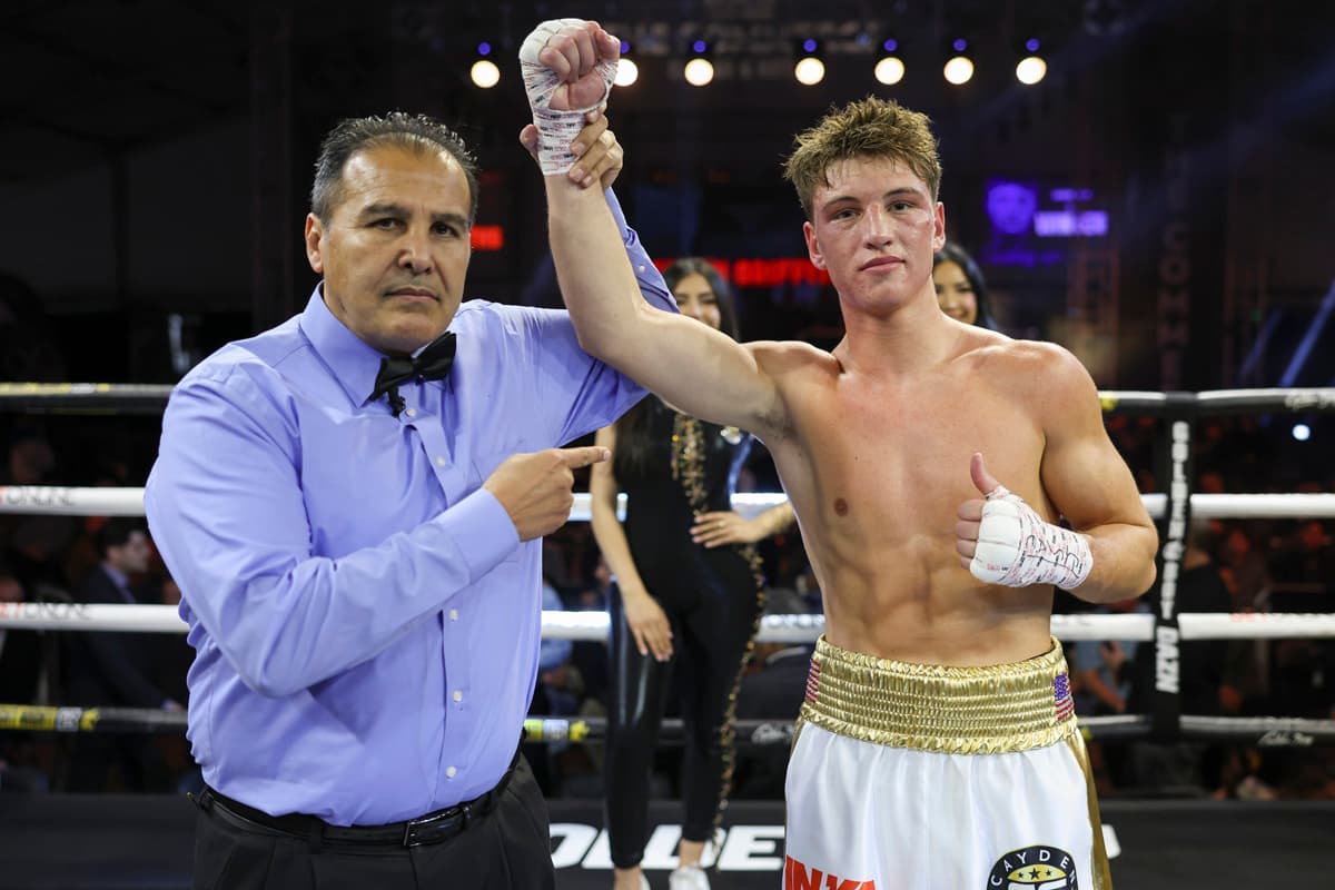 Referee Rudy Barragan raises boxer Cayden Griffiths' hand in victory