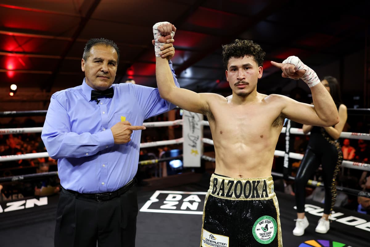 Referee Rudy Barragan raises boxer Leonardo Sanchez's hand in victory