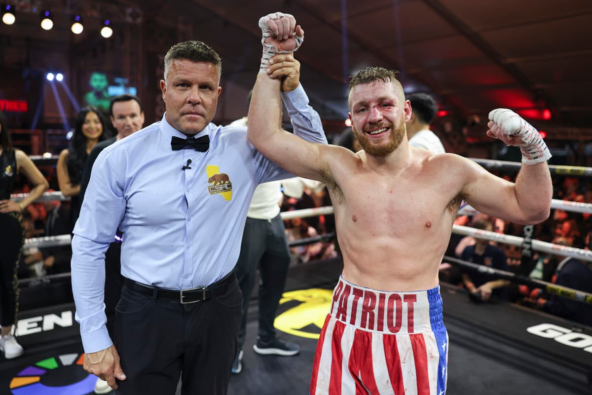 Referee Thomas Taylor raises boxer Jordan Panthen's hand in victory