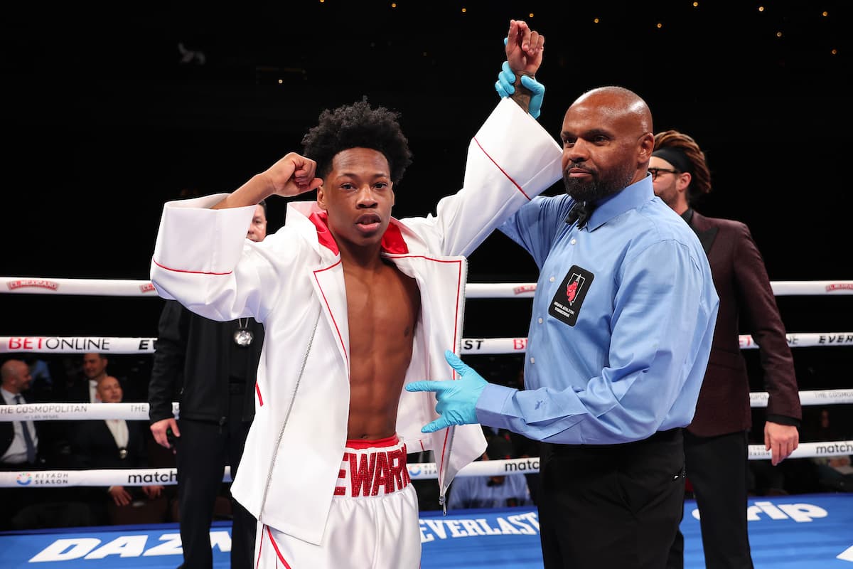 Referee Robert Hoyle raises boxer Zaquin Moses' hand in victory