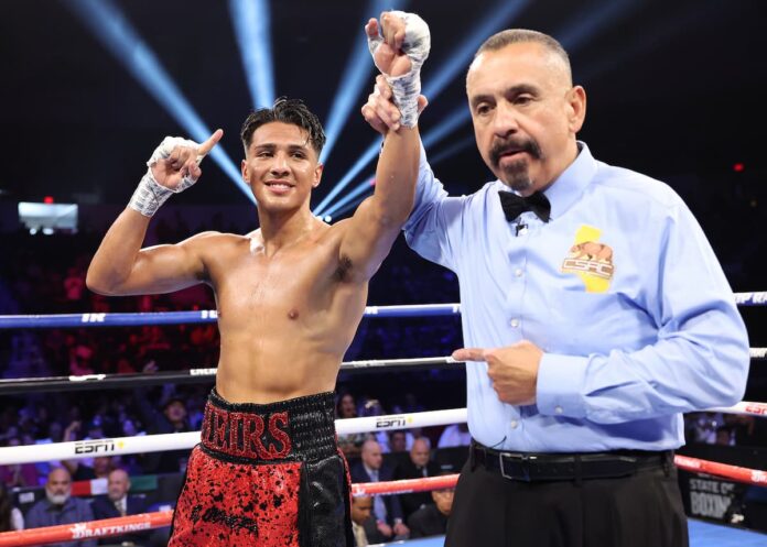 Referee Ray Corona raises Emiliano Vargas' hand in victory after his boxing match against Angel Varela Urena