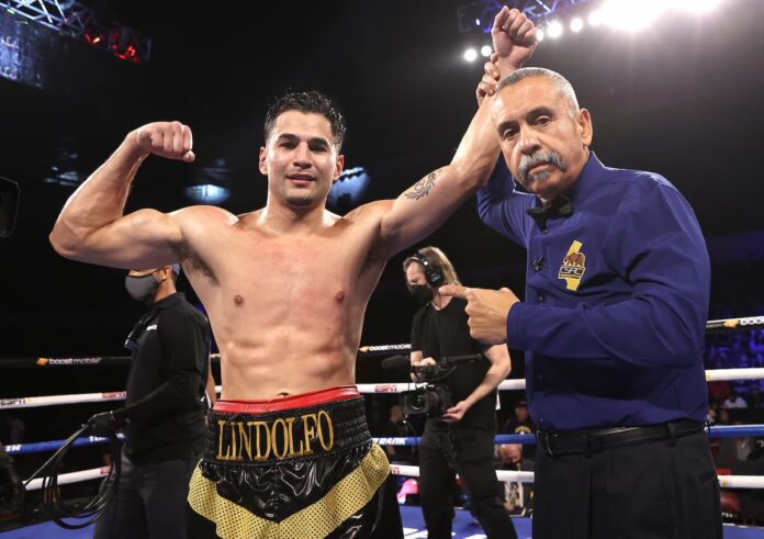 Referee Ray Corona raises Lindolfo Delgado's hand after his victory over Juan Garcia Mendez