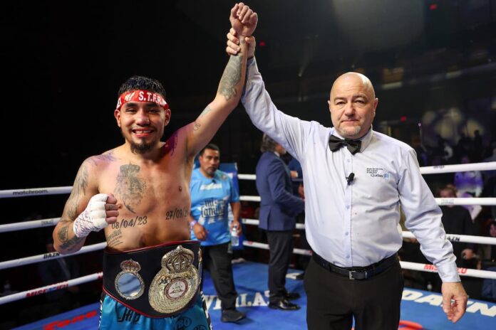 Referee Albert Padulo Jr raises Eduardo 'Rocky' Hernandez's hand in victory over Rene Tellez Giron