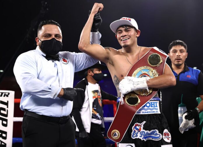 Referee Samuel Burgos raises Emanuel Navarrete's hand in victory after his win over Christopher Diaz-Velez